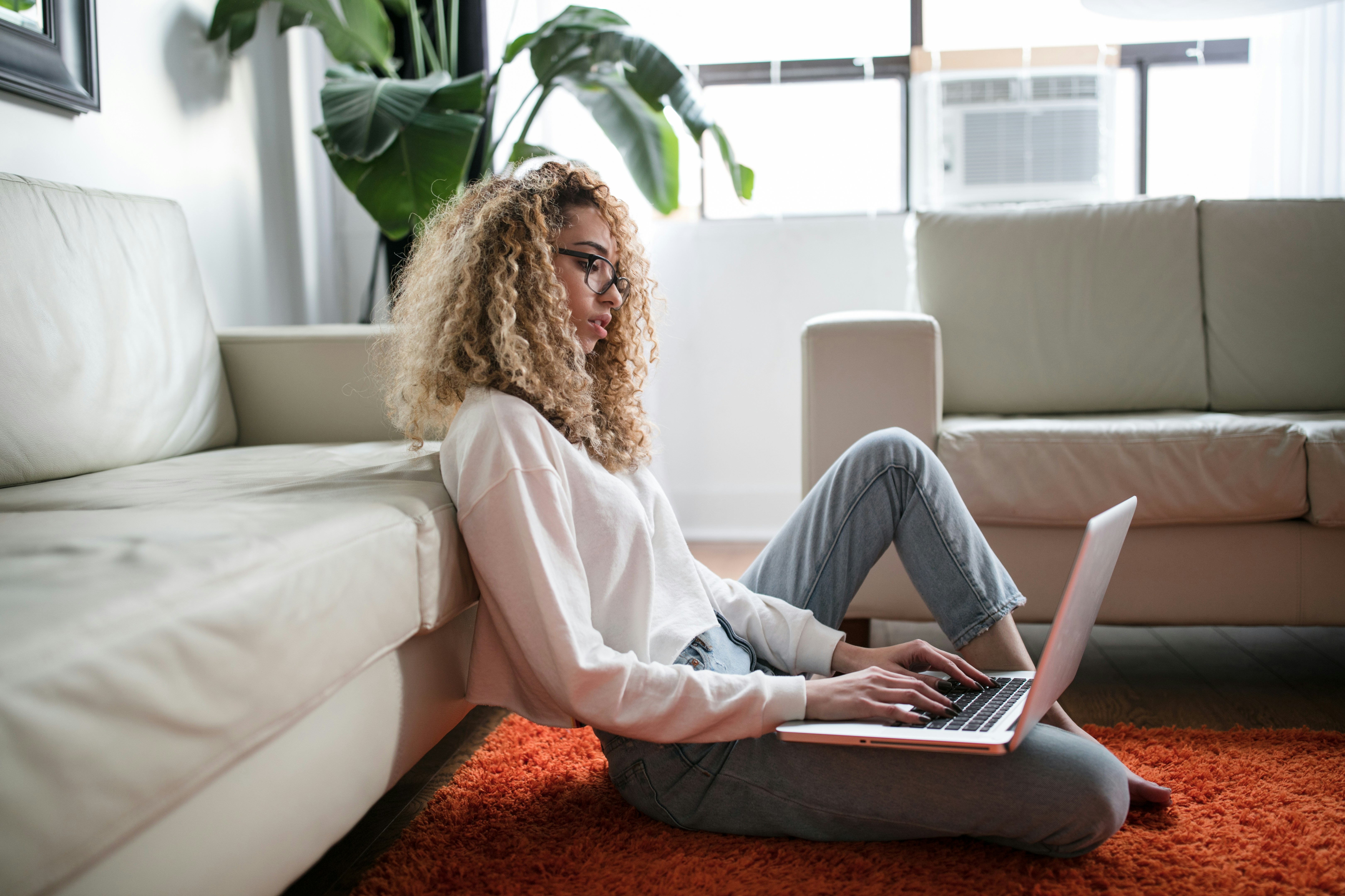 Woman relaxing on couch with headphones and laptop